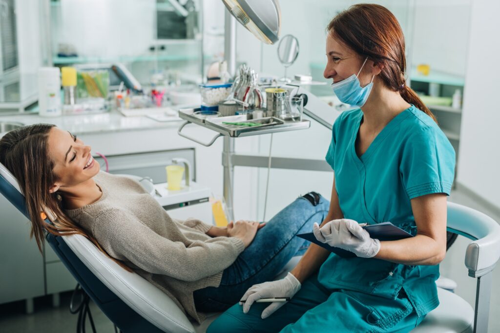 a doctor laughing with her patient during a dental exam